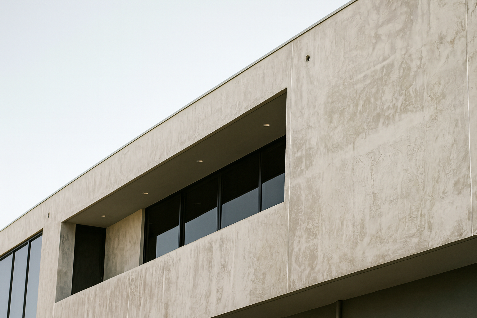 Contemporary building with textured concrete façade and integrated glass panels.