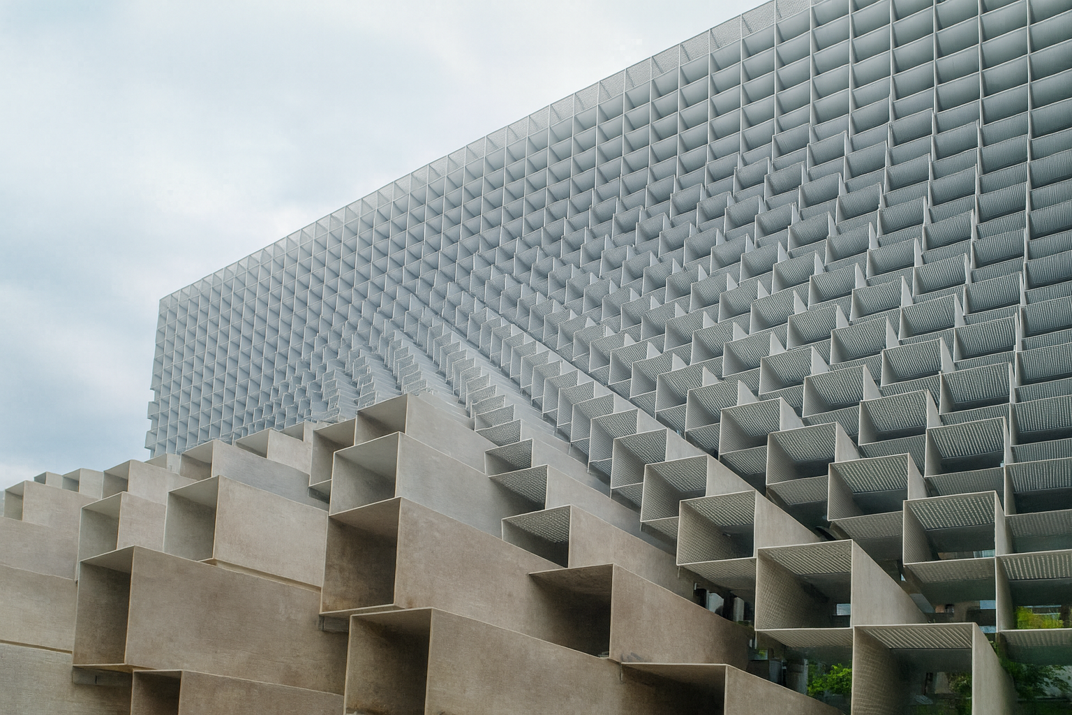 Modern building façade with modular concrete grid design and sculptural geometry