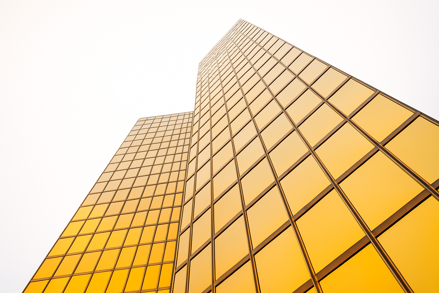 Upward view of a modern glass skyscraper with golden reflections.