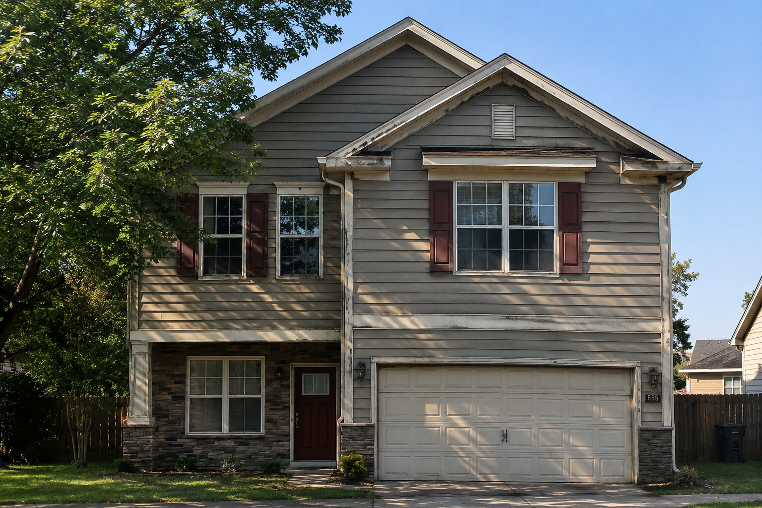 Two-story suburban house with a cross-gable roof, front-facing gable projections, horizontal siding, and an attached garage.