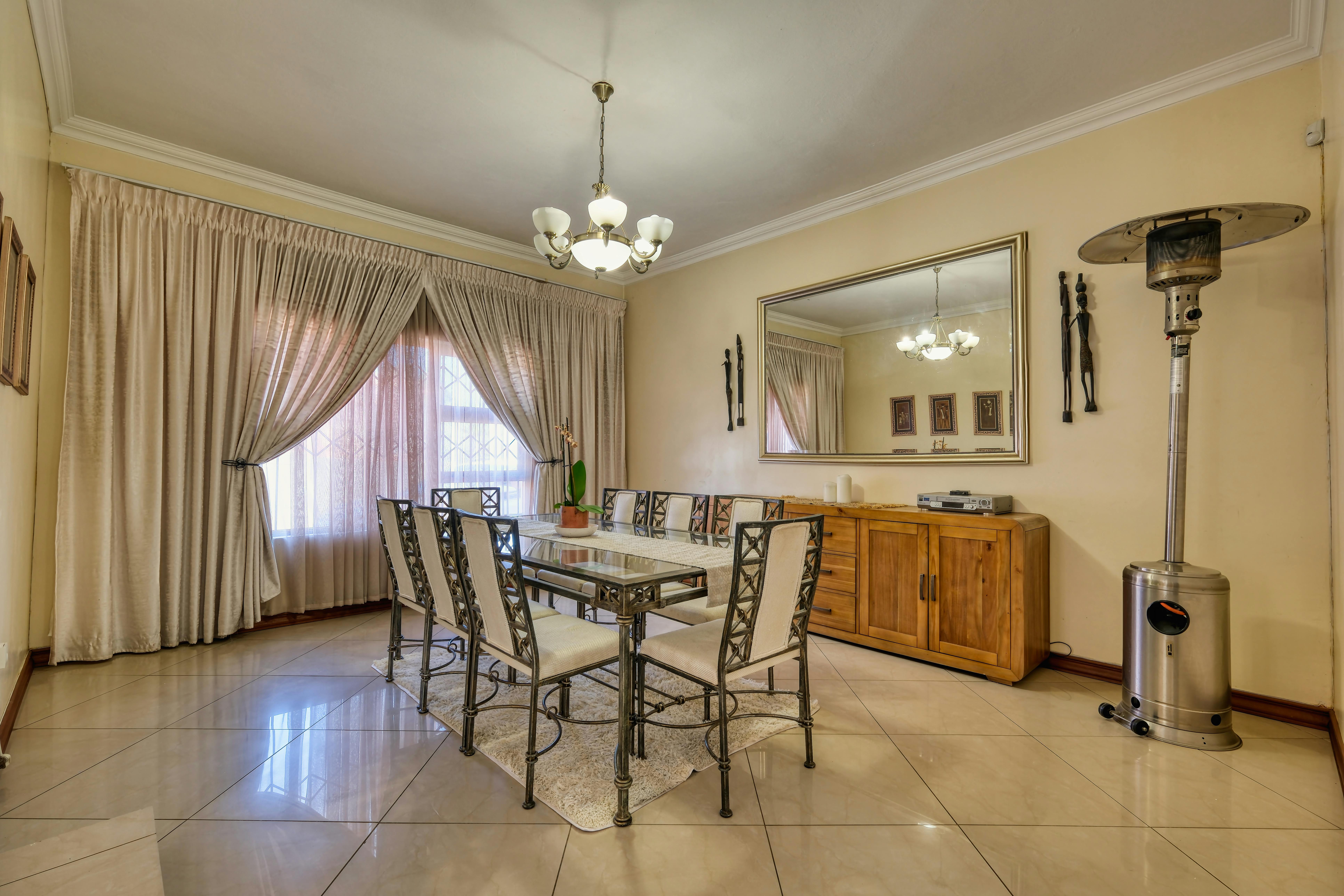 Luxurious traditional American dining room with a grand chandelier, carved wood table, and classic wainscoting details.