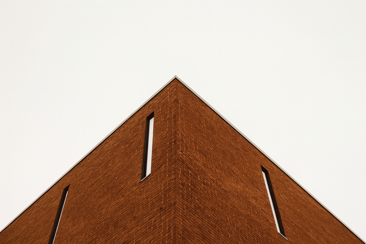 Old brick building modernized with sleek contemporary narrow windows.
