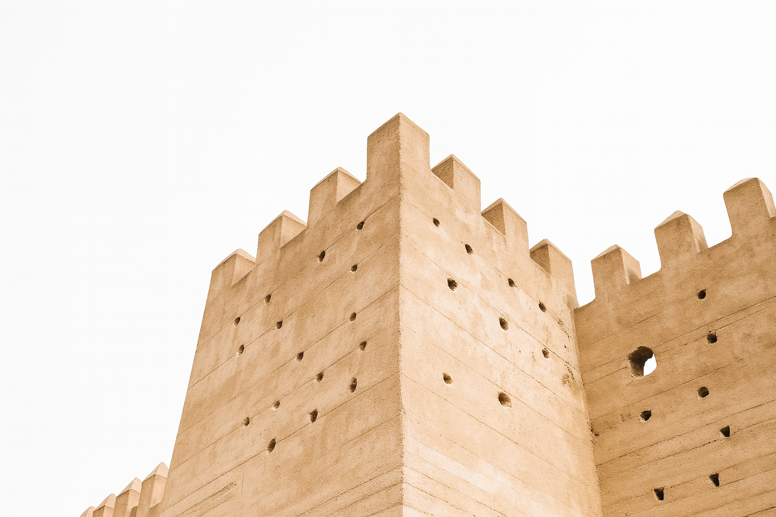 Rammed earth adobe wall in Fès, Morocco with geometric battlements.