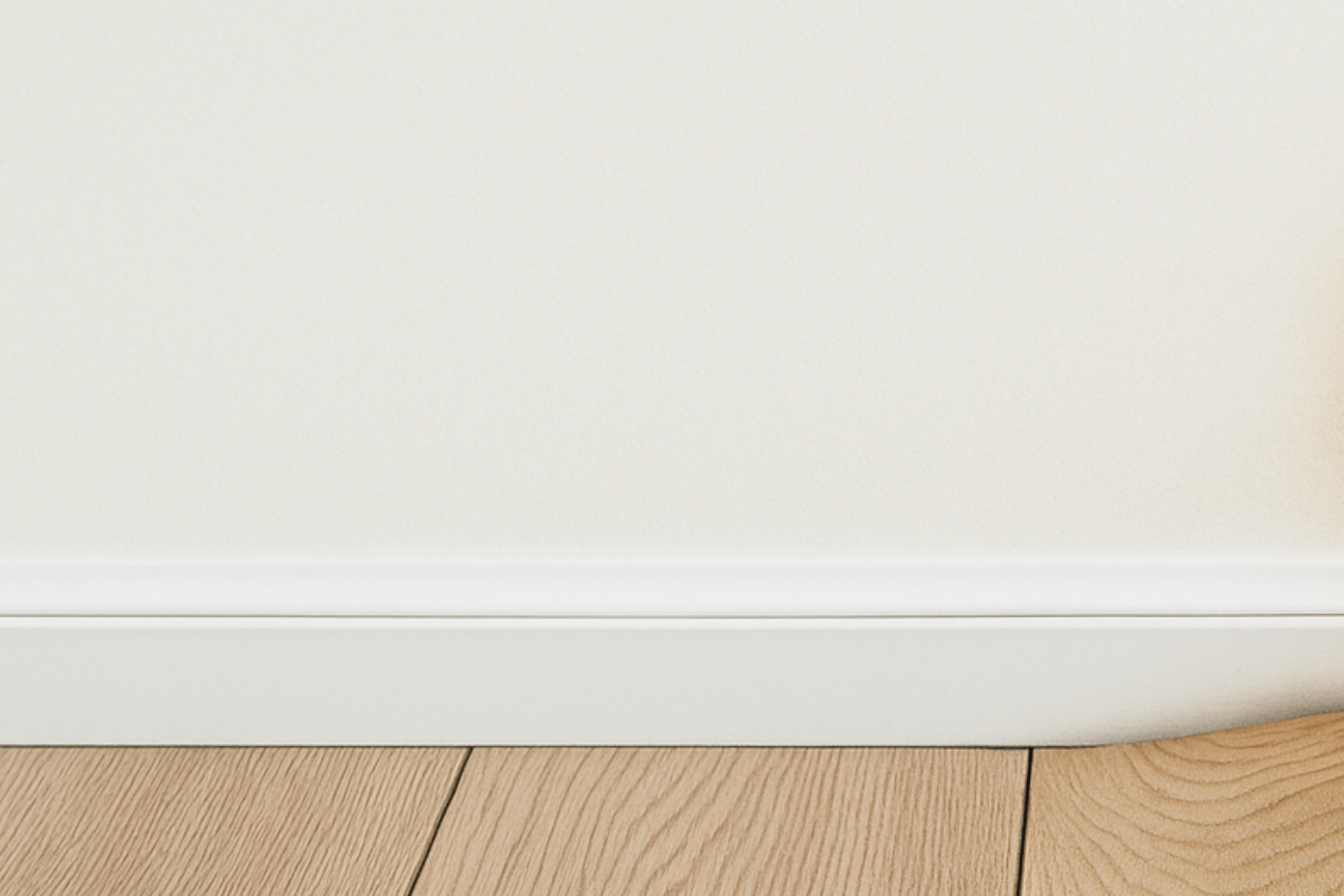 A close-up of a hardwood floor showing water damage and board warping near a wall.