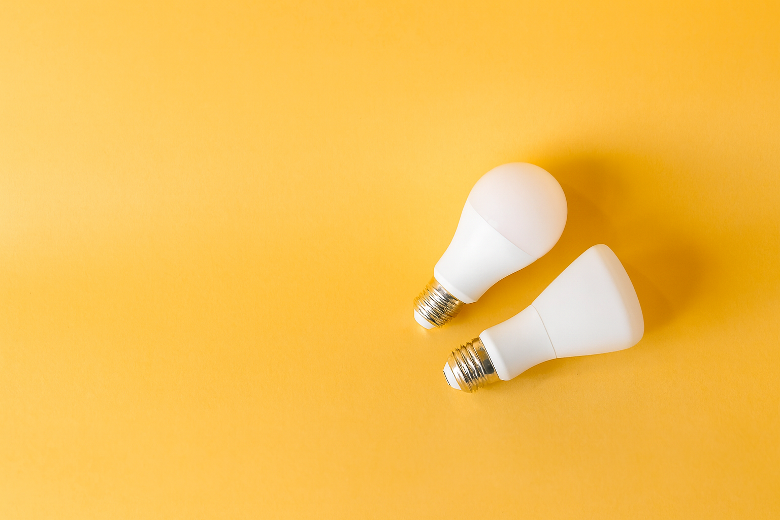 Contemporary LED bulbs displayed on a yellow background, showing efficient home lighting options.