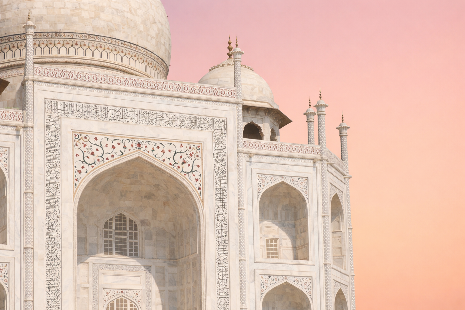 Close-up of the Taj Mahal facade: main iwan arch framed by Quranic calligraphy bands and floral pietra dura inlay.