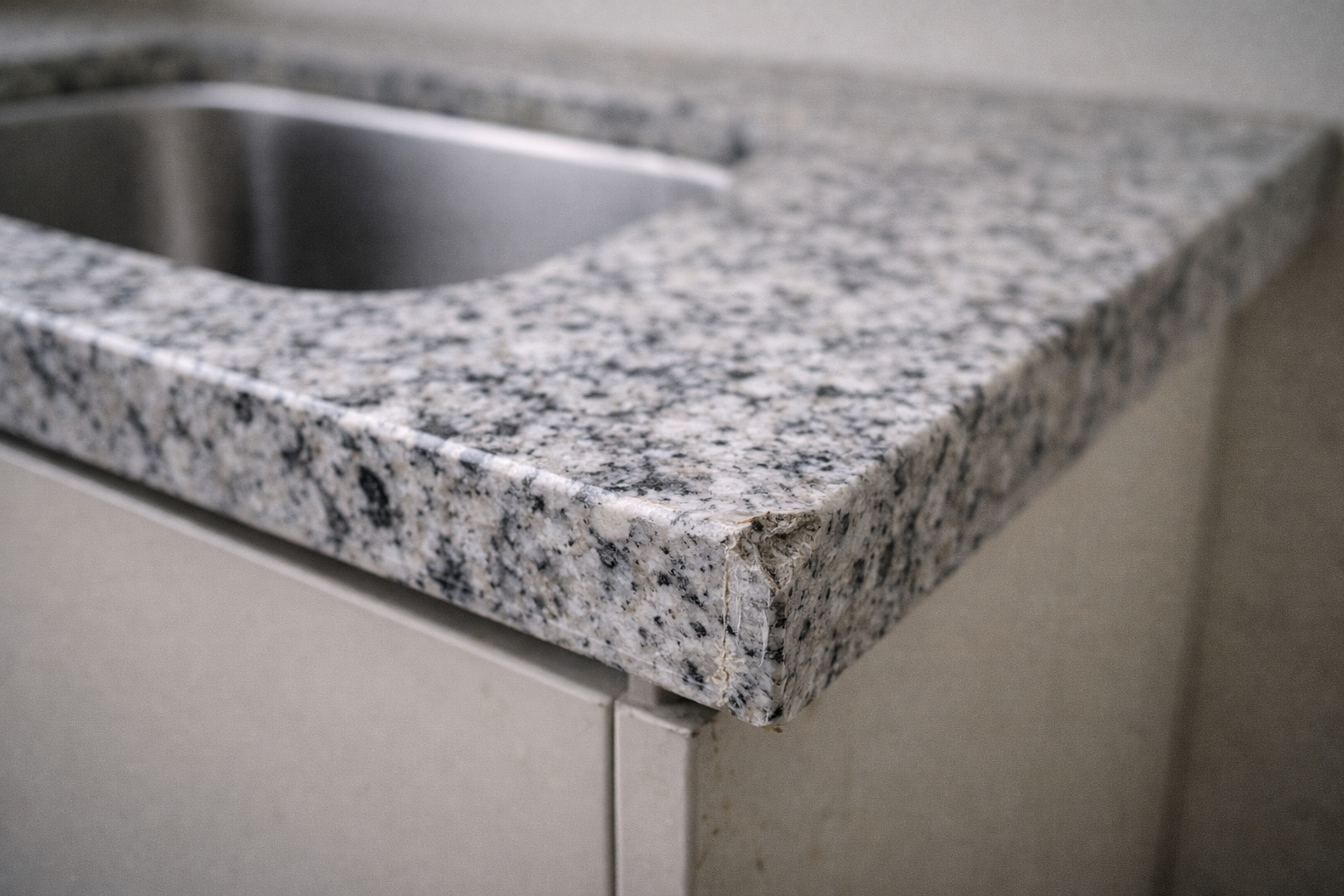 Natural granite showing a typical chip at a thin cutout corner.