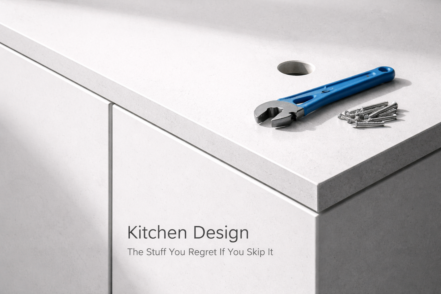 Close-up of unfinished kitchen countertop with faucet hole, screws, and wrench showing planning stage installation.