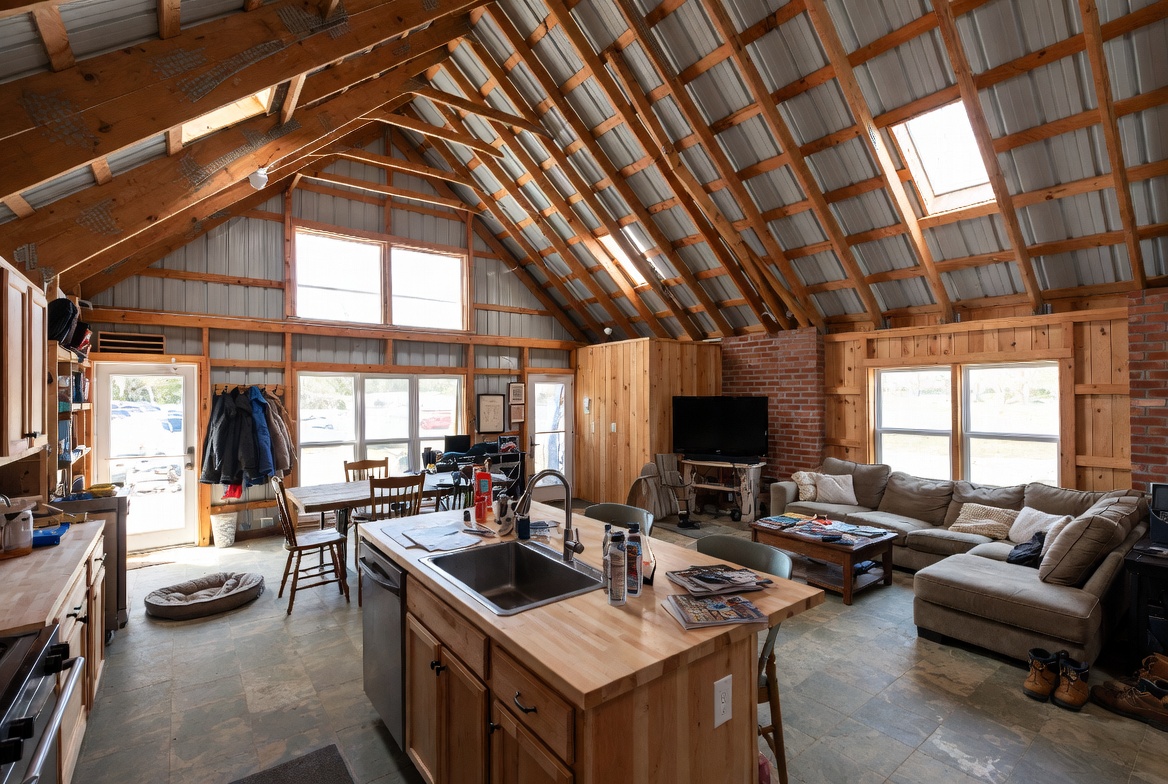 Barndominium interior showing everyday living space with kitchen, seating, and exposed framing.