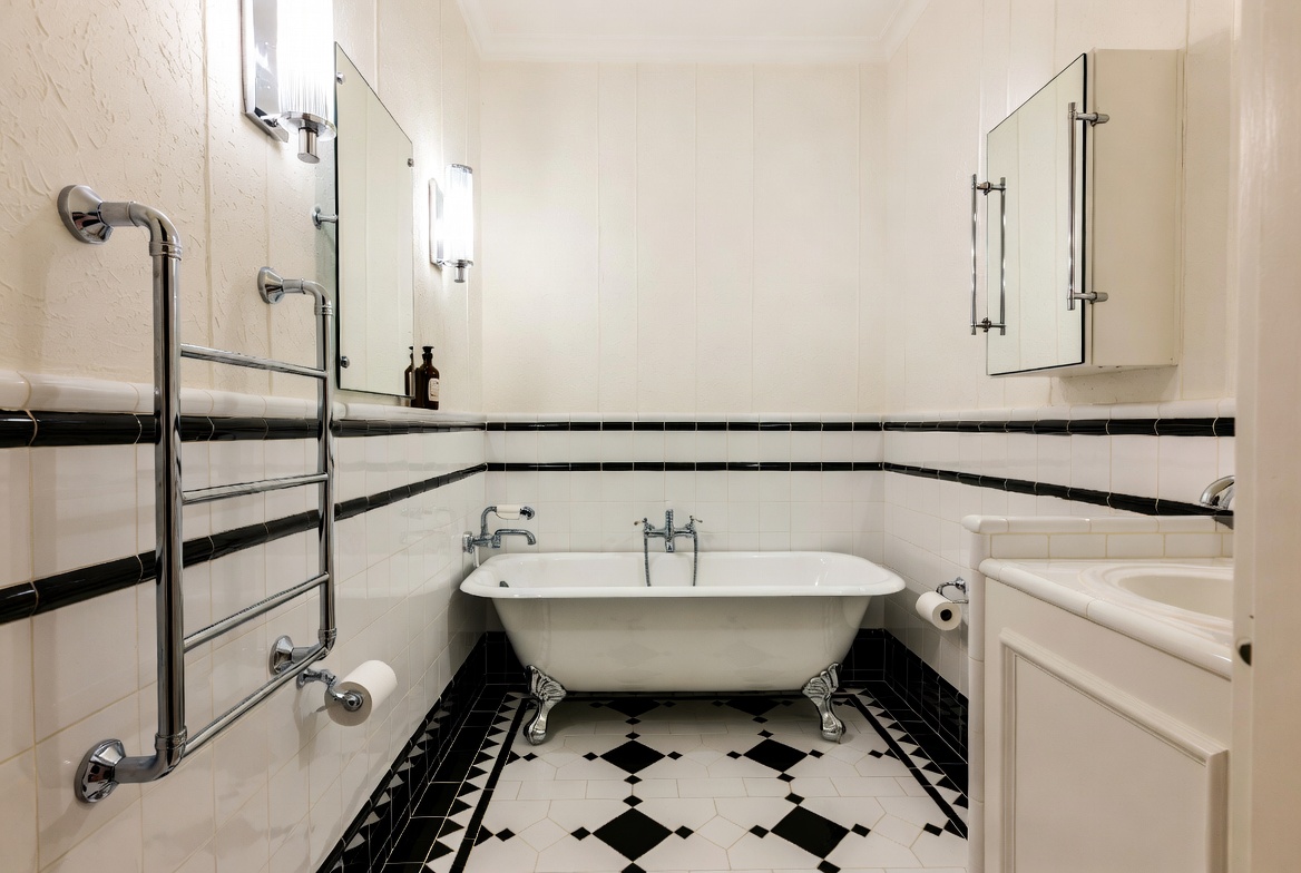 Close view of Art Deco bathroom tile, mirrored cabinet, chrome fittings, and vanity lights.
