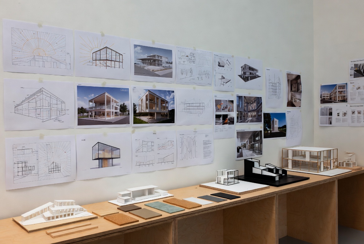 Architecture studio wall with sustainable design course boards, models, and material samples.