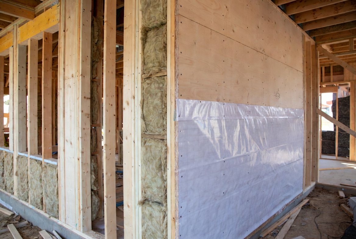 Fiberglass batt wall insulation installed in a wood-frame building under construction.