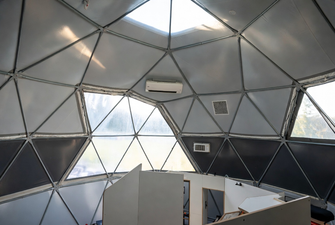 Geodesic dome interior with visible faceted shell, skylight, vents, and mini-split HVAC.