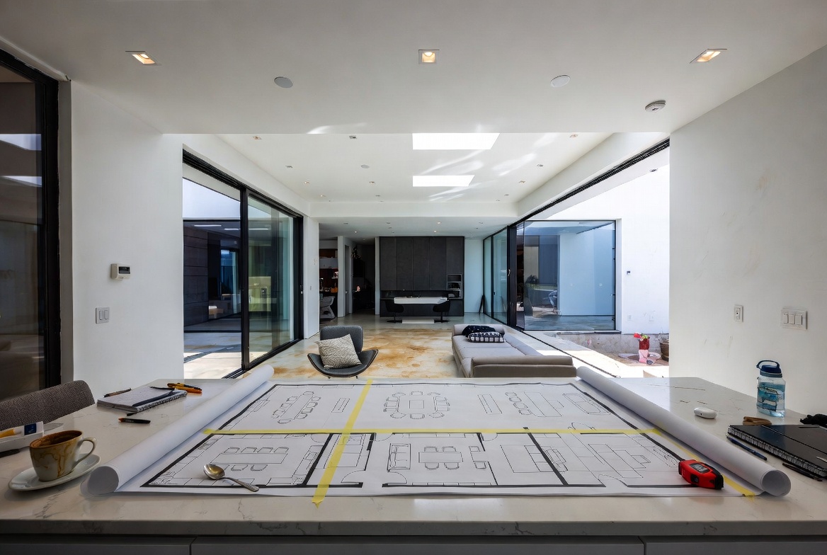 Blue tape and floor plan in modern home space planning session.
