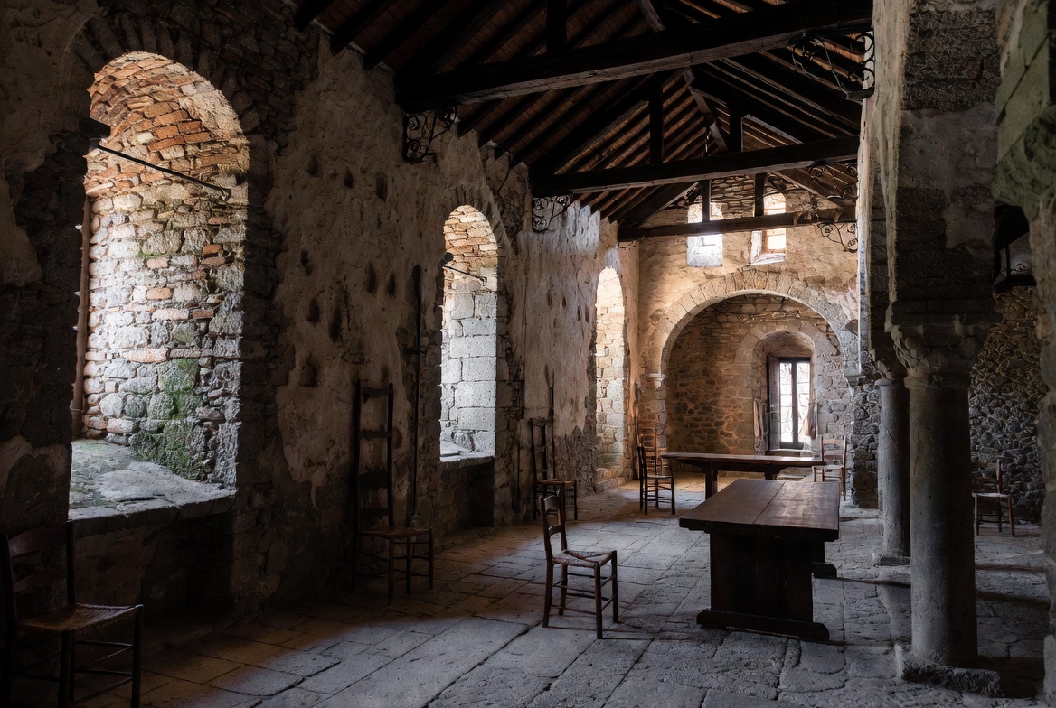 Romanesque stone interior with round arches and heavy masonry.