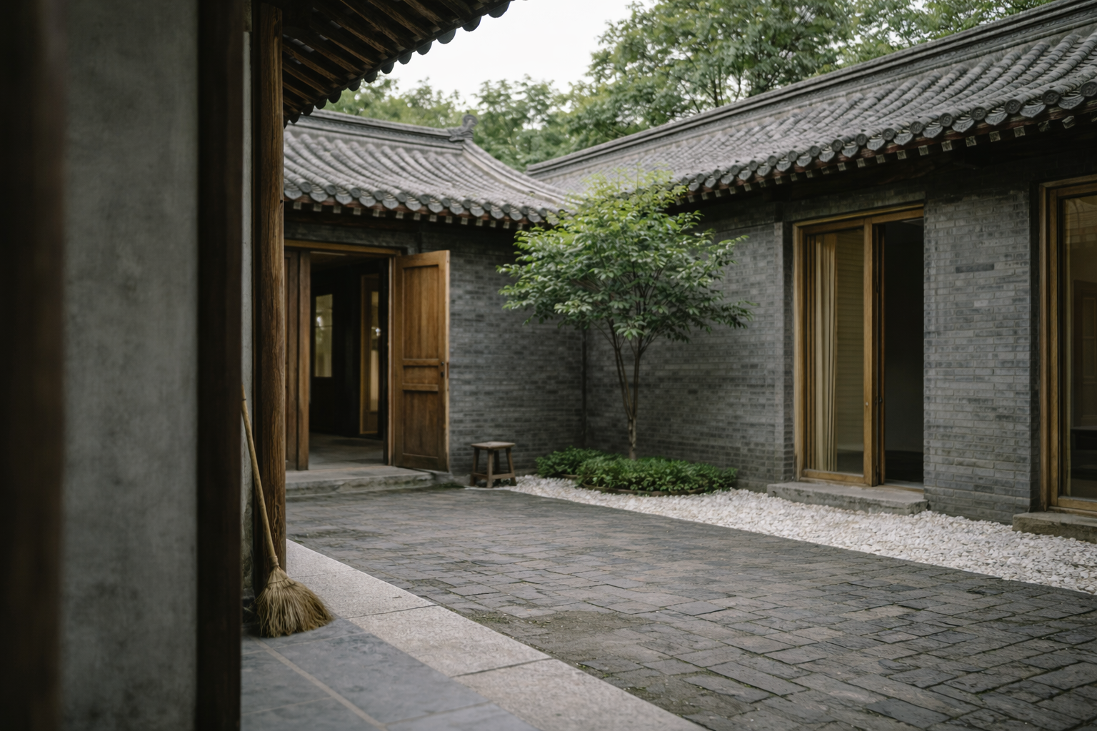 Chinese siheyuan courtyard corner view with gray brick walls, timber doors, roof tiles, and tree.