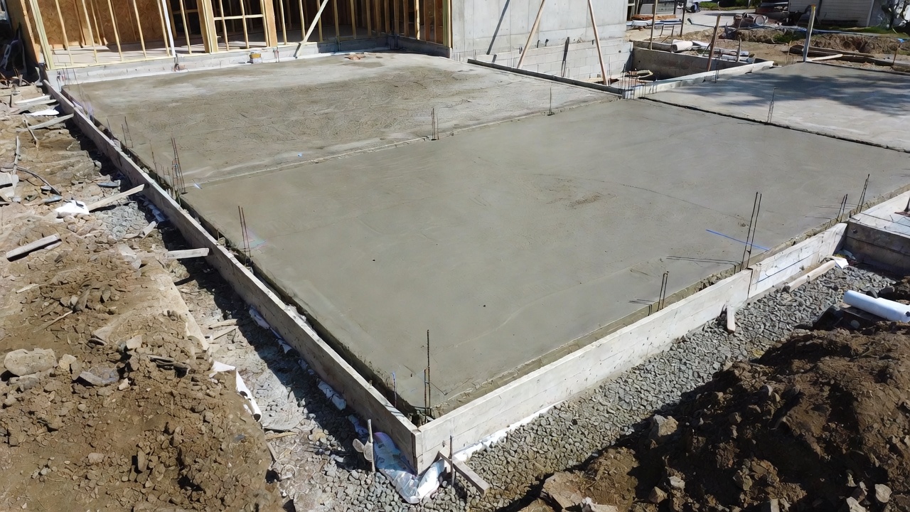 Slab-on-grade foundation at a residential building site before framing and exterior walls.