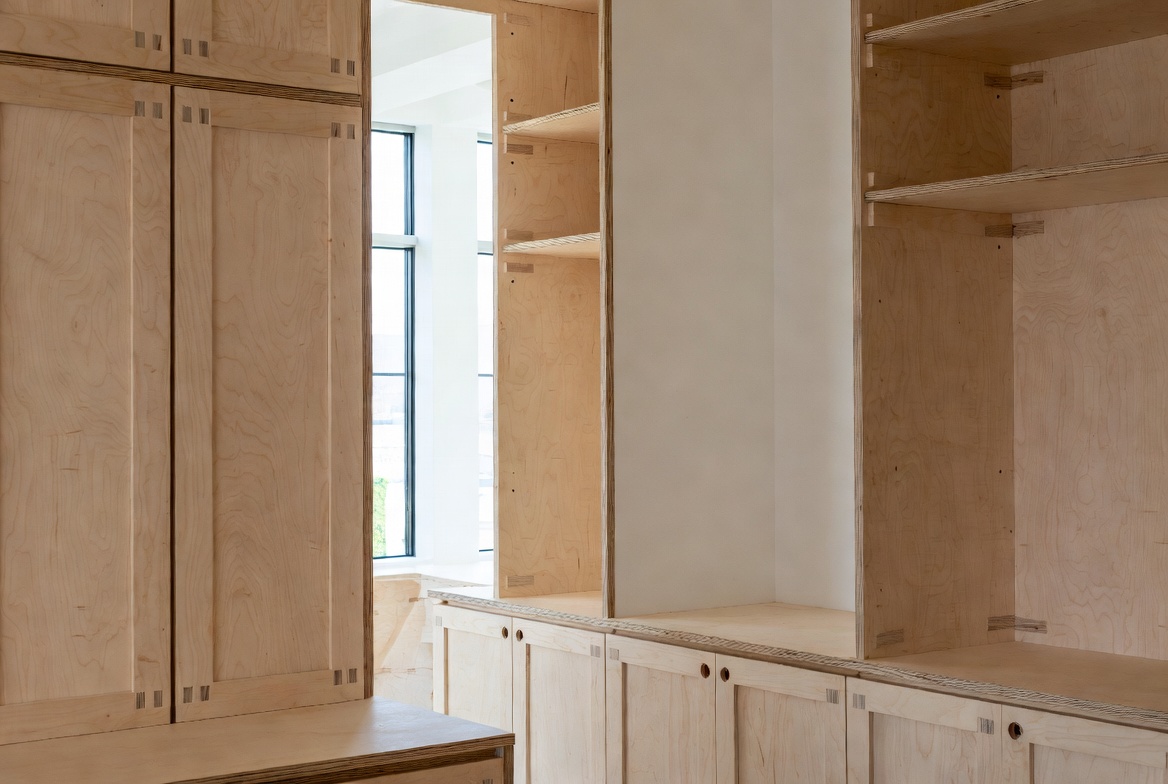 Plywood cabinetry and built-in storage made with sustainable wood in a bright interior.