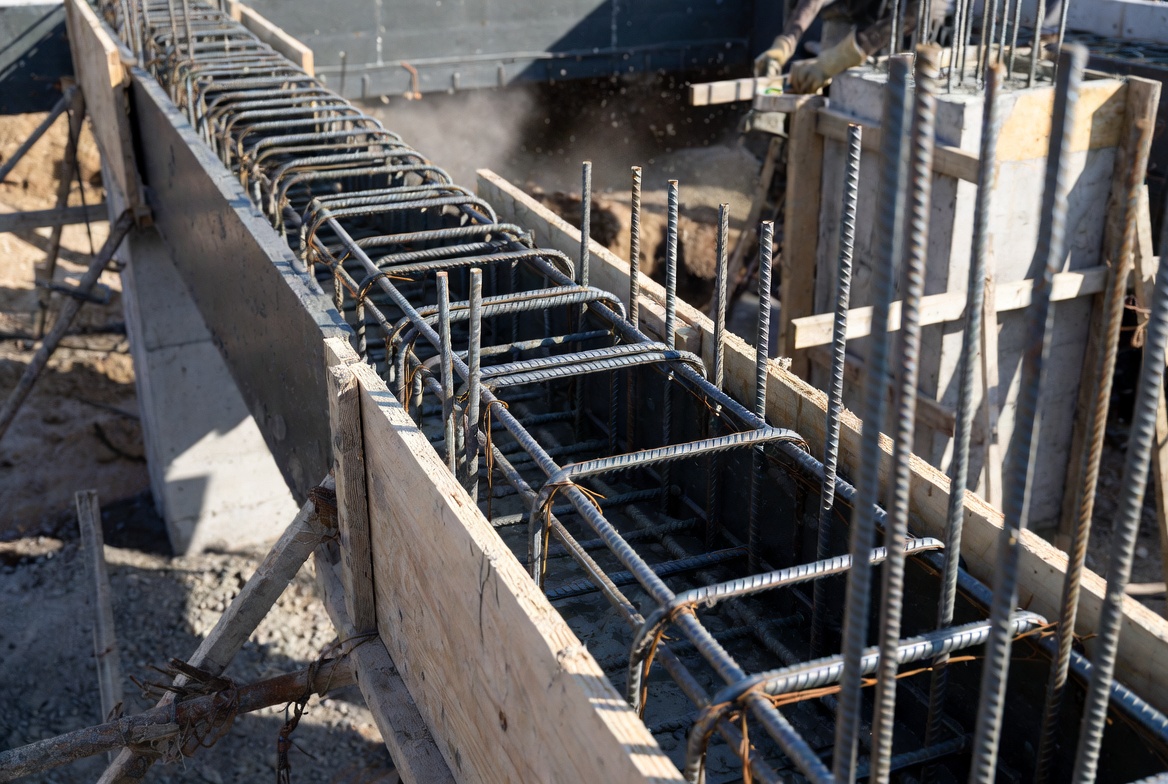 Reinforced concrete tie beam formwork with rebar cage before pour.