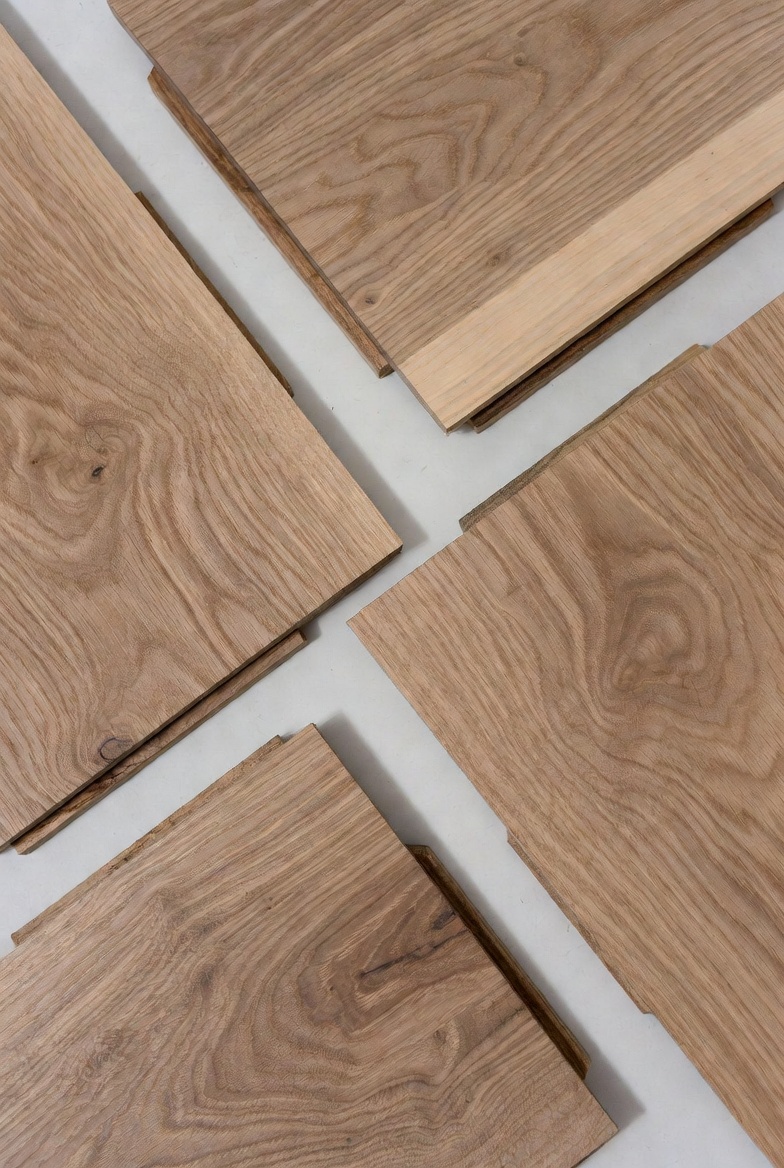 Hardwood floorboards arranged on a white background with visible grain and tongue-and-groove edges.