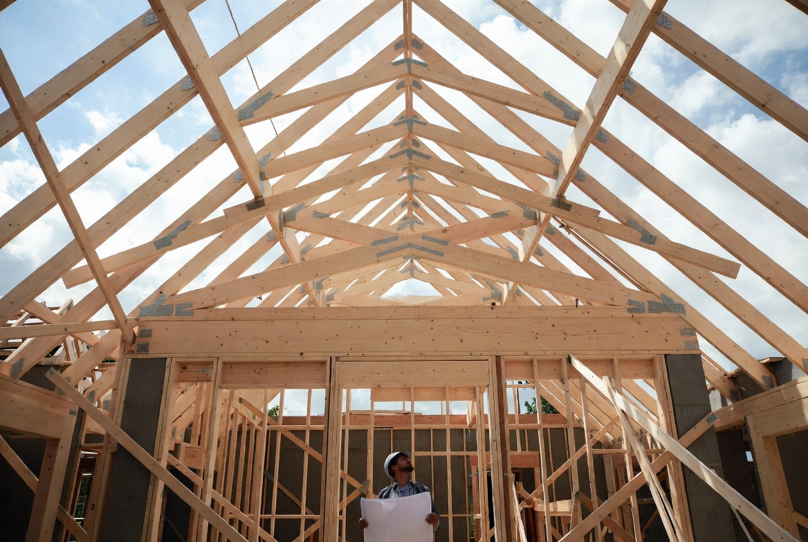 Exposed wood roof trusses during residential house framing before roof sheathing is installed.