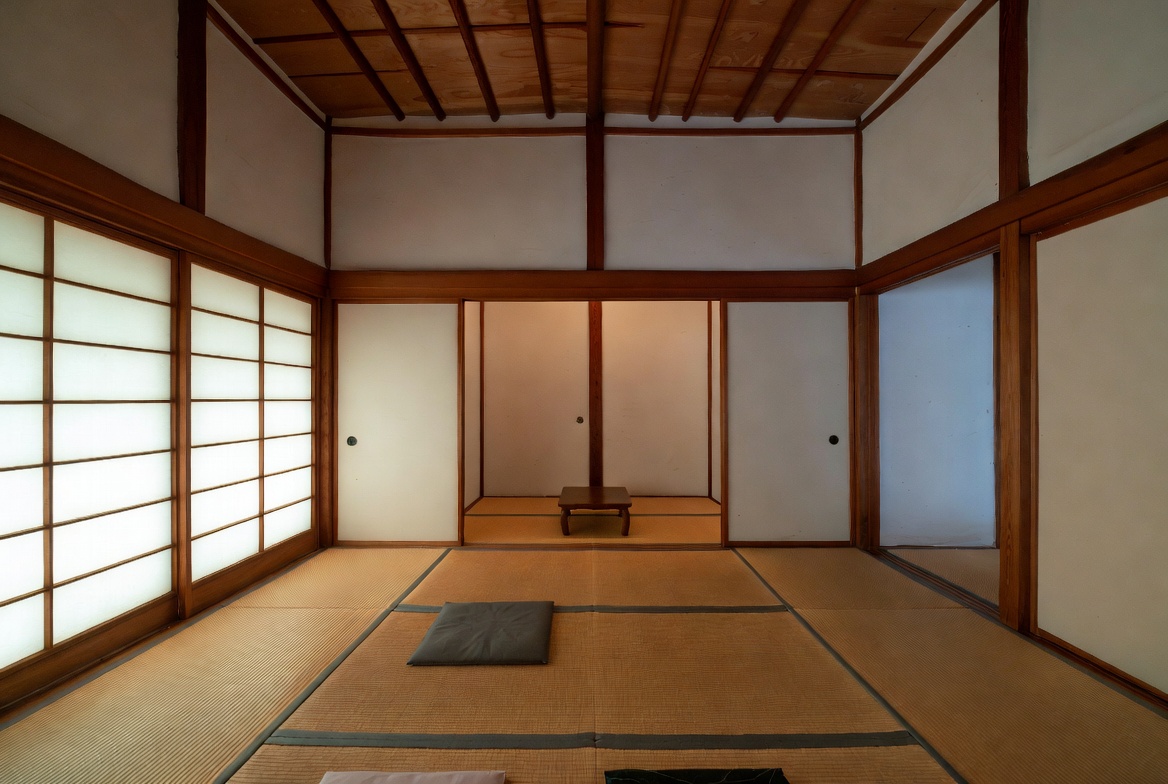 Traditional Japanese interior with tatami mats, shoji screens, and a simple tokonoma-style alcove.