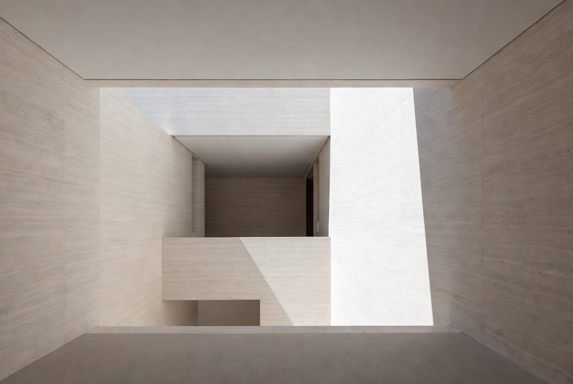 Interior void with projecting balcony edge, strong shadow, and open sky above.