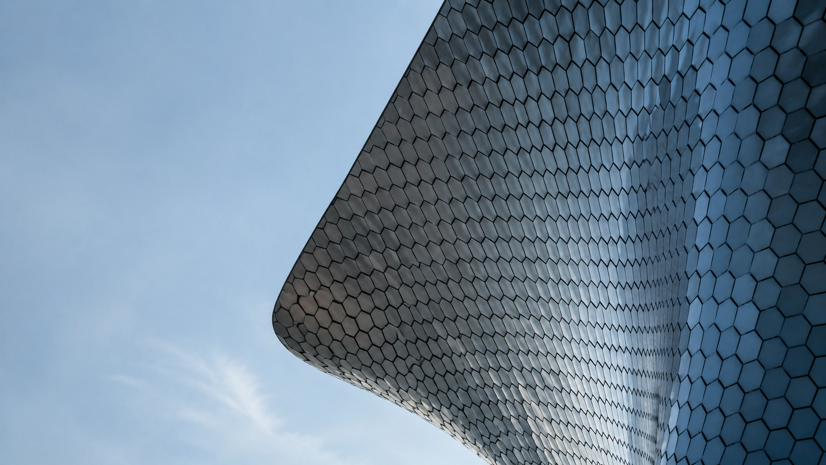 Ultra-modern glass exterior showing large transparent wall surfaces, thin structural lines, and a clean contemporary building envelope.