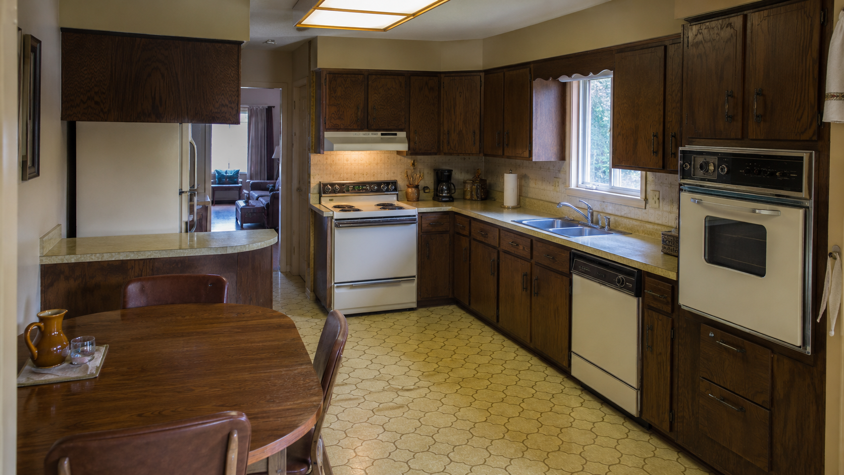Dated 1970s kitchen before remodel with dark wood cabinets, soffits, linoleum floor, and older appliances.