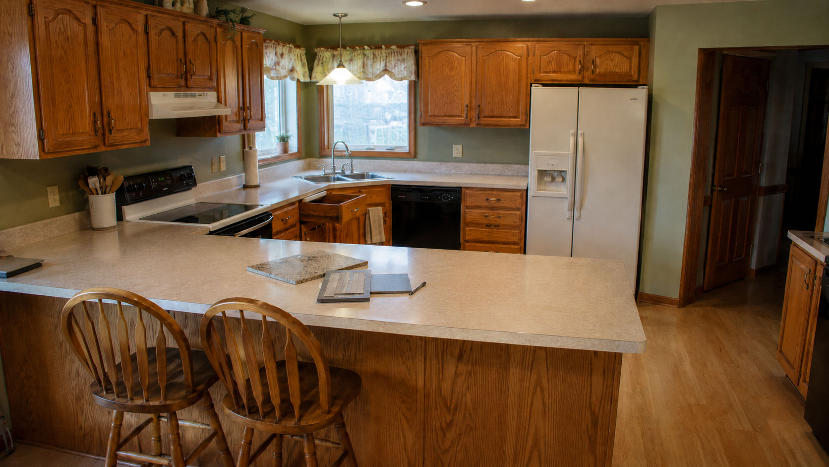 1990s oak kitchen with cabinet door, hardware, and countertop samples used to compare finishes.
