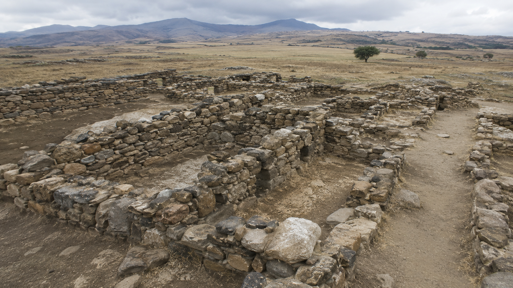 Early stone settlement walls in a dry archaeological landscape.