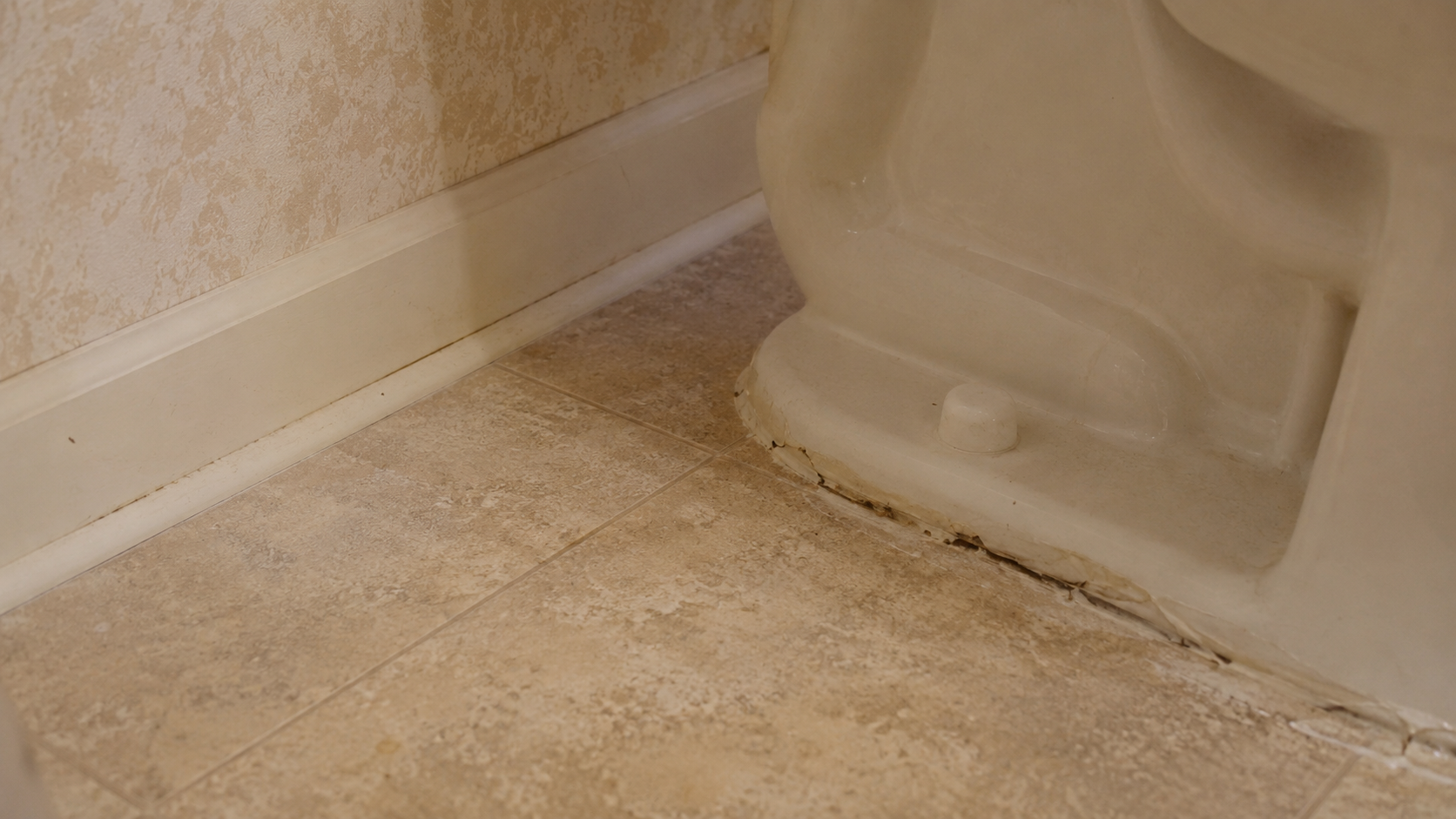 1990s bathroom floor edge near toilet checked for leaks and subfloor damage.