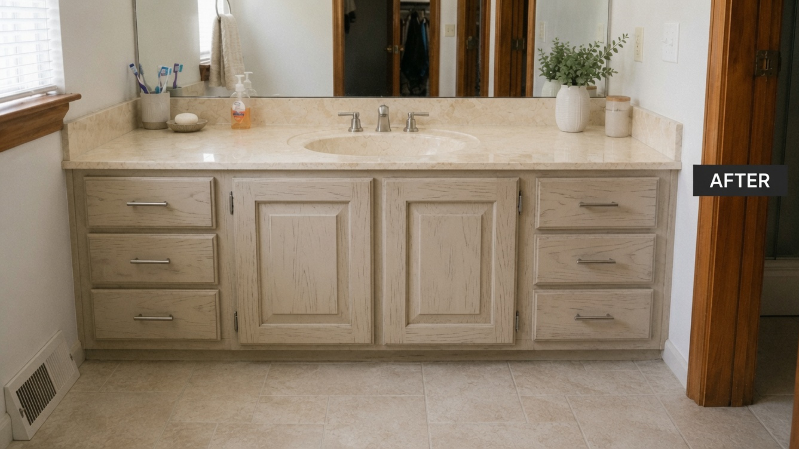 Updated 1980s bathroom vanity with painted cabinet, warm cultured marble top, new floor, mirror, and faucet.