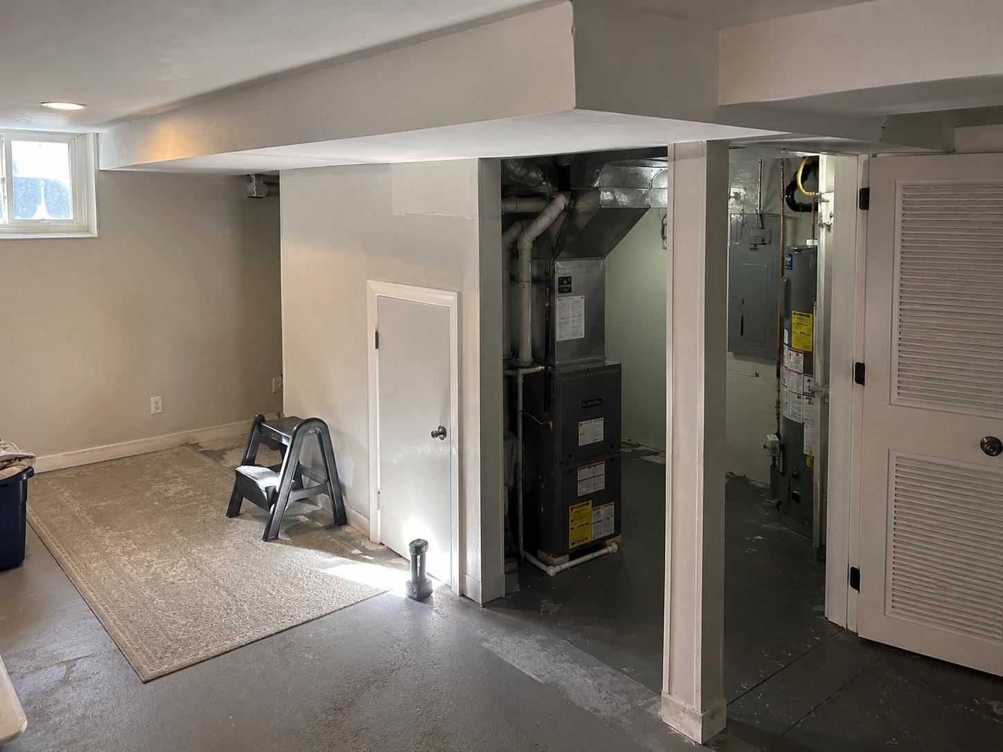 Basement remodel mistake with boxed-in ducts, low ceiling, and crowded mechanical access.