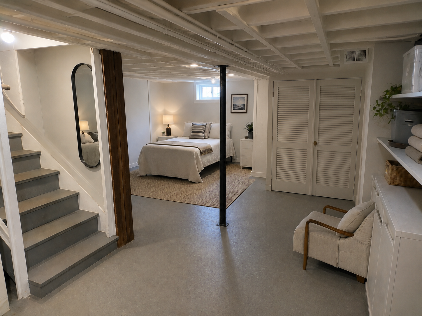 Cape Cod basement guest suite with low ceiling, daylight window, bed, clear path, and service access.