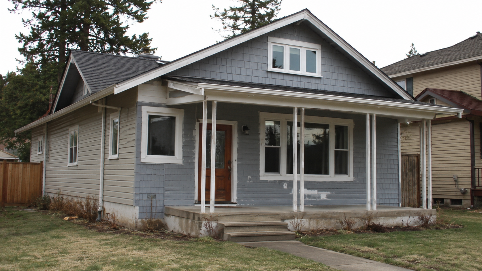 Craftsman house with thin porch posts and awkward exterior updates.