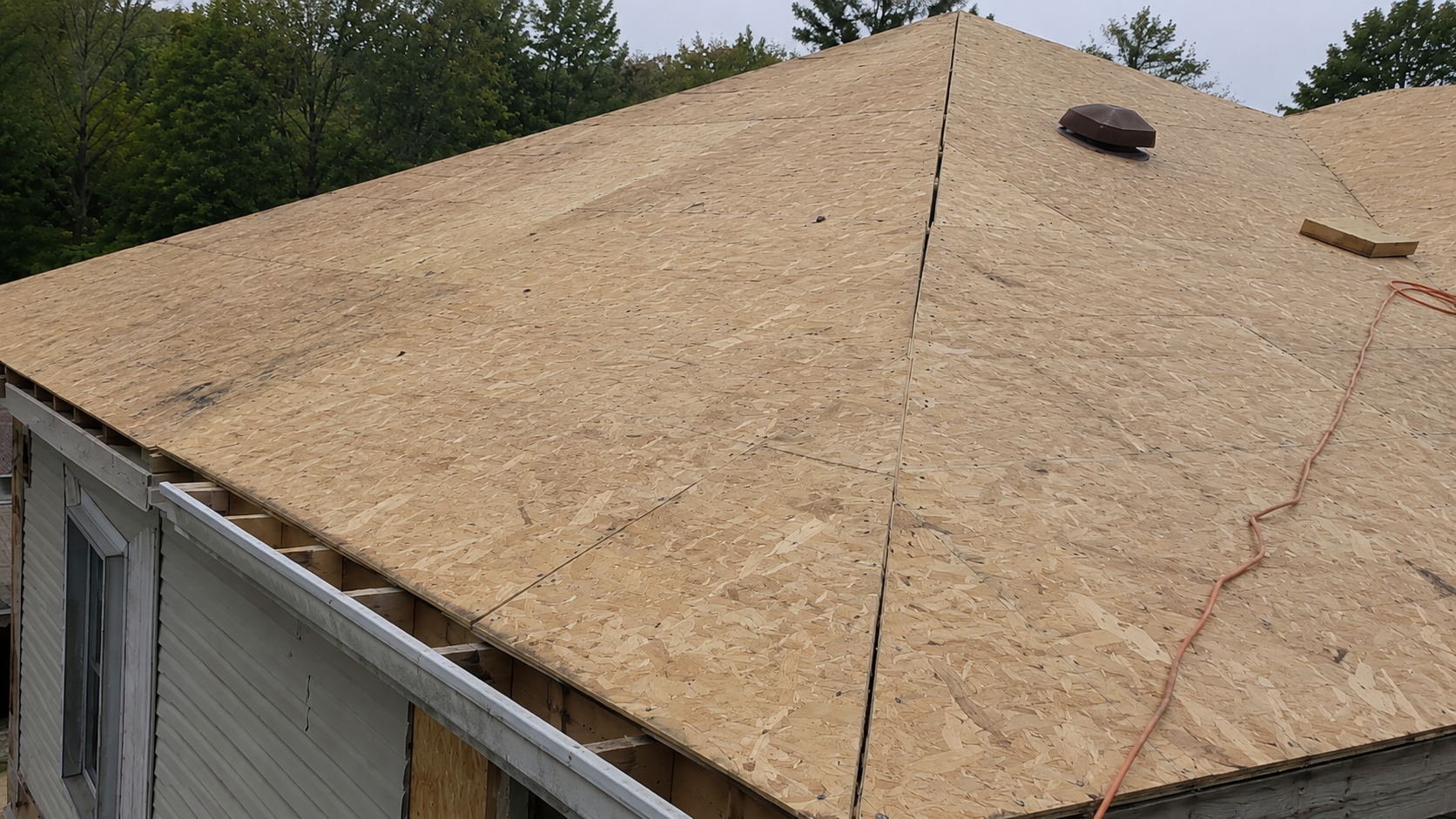 Roof sheathing panels installed over a house roof before underlayment and shingles.