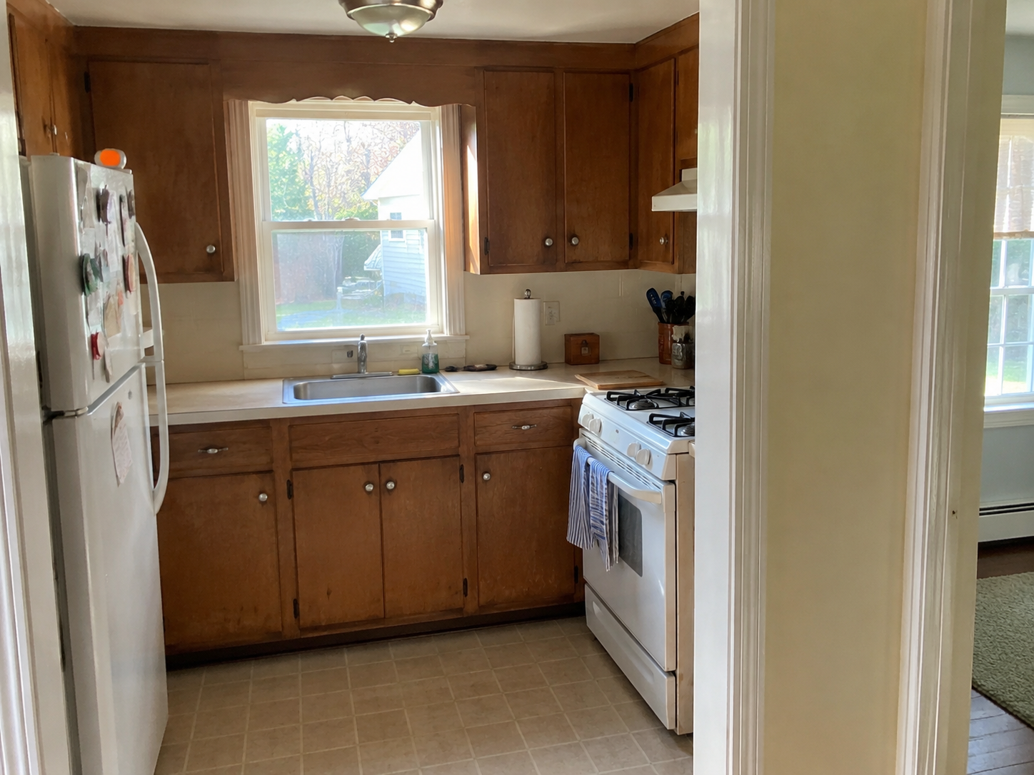 Older small Cape kitchen before remodel with dated cabinets, tight layout, and limited workspace.