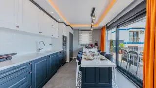 Modern kitchen with white upper and blue lower Shaker-style cabinets.