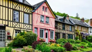Row of colorful Tudor-style houses in France with timber detailing and vibrant facades