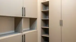 Kitchen with cream cabinets fitted with black hardware for a modern, contrasting look.