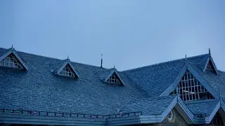 A large house featuring a combination of hip and gable roofs, showcasing architectural complexity.