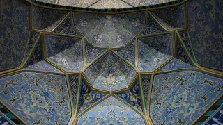 The stunning ceiling of the Imam Mosque in Isfahan, Iran, showcasing intricate Islamic architectural details and vibrant patterns.