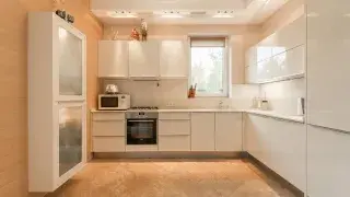 Minimalist kitchen with glossy cream cabinets, featuring a sleek and modern design.