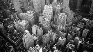 Aerial grayscale photograph of New York's high-rise buildings, emphasizing their urban scale.