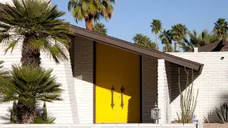 Mid-century modern house exterior in Palm Springs with clean lines, flat roof, and expansive glass windows.​
