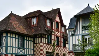 Tudor-style house with a red and white tiled roof in Deauville, France.