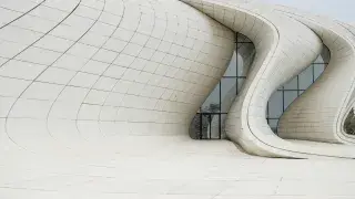 Heydar Aliyev Center in Baku, designed by Zaha Hadid, featuring fluid, organic forms with sweeping curves and dynamic lines.