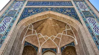 Ornate brick and tile entrance of Ulugh Beg Madrasa in Samarkand, Uzbekistan.