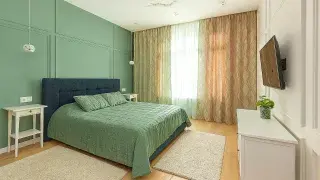 A bedroom with visible water-damaged ceiling and peeling plaster near the center of the room.